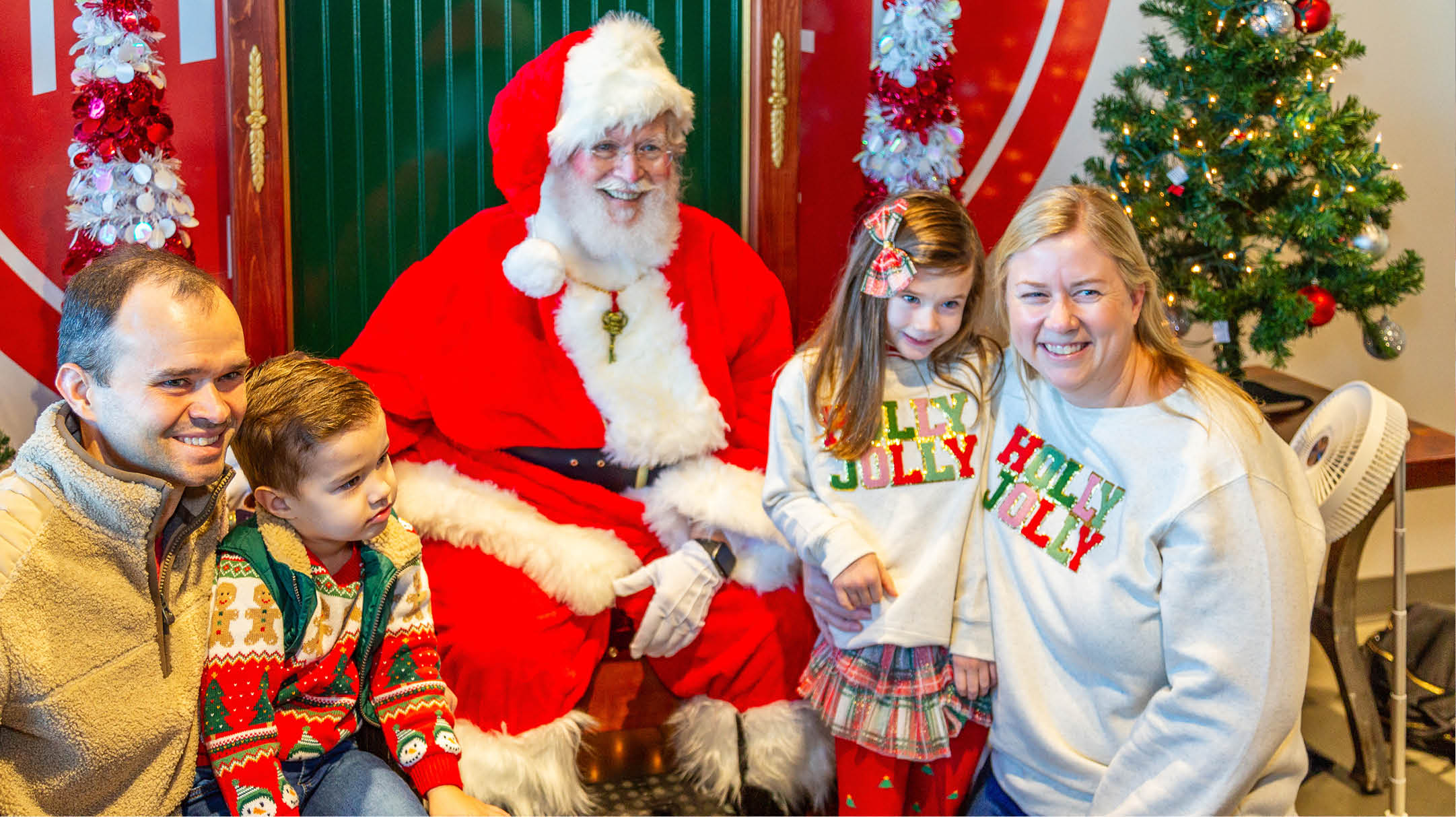 Family of four posing with Santa Claus